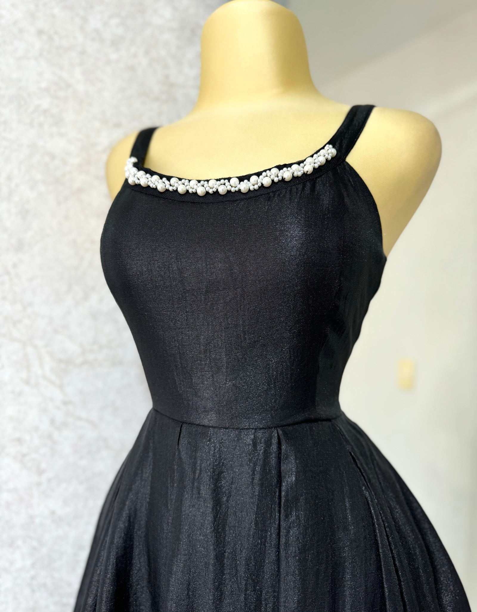 Vestido negro tela brillosa con perlas